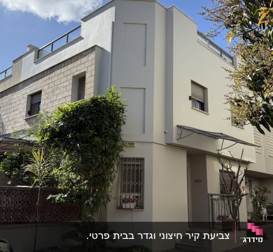 בניין מגורים עם חזית מודרנית ועצים מסביב